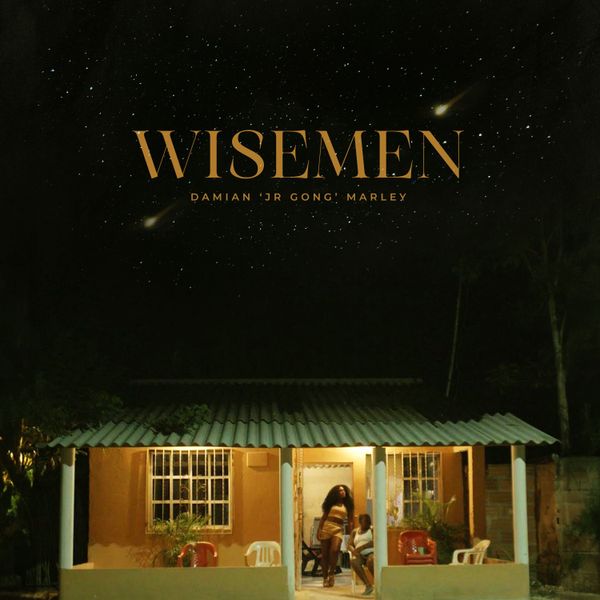 The image is the cover art for Damian Marley's single "Wisemen." The artwork features a small house at night, warmly lit from within, with two people standing in the doorway. Above the house, a starry night sky is prominently displayed, with the title "WISEMEN" written in large, golden letters. Below the title, Damian 'Jr Gong' Marley's name is written in a smaller font. The overall atmosphere is serene and inviting, combining the warmth of the home with the vastness of the night sky.
