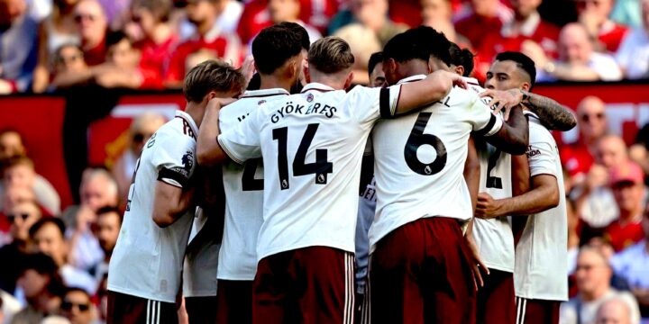Arsenal players celebrate a goal against Manchester United